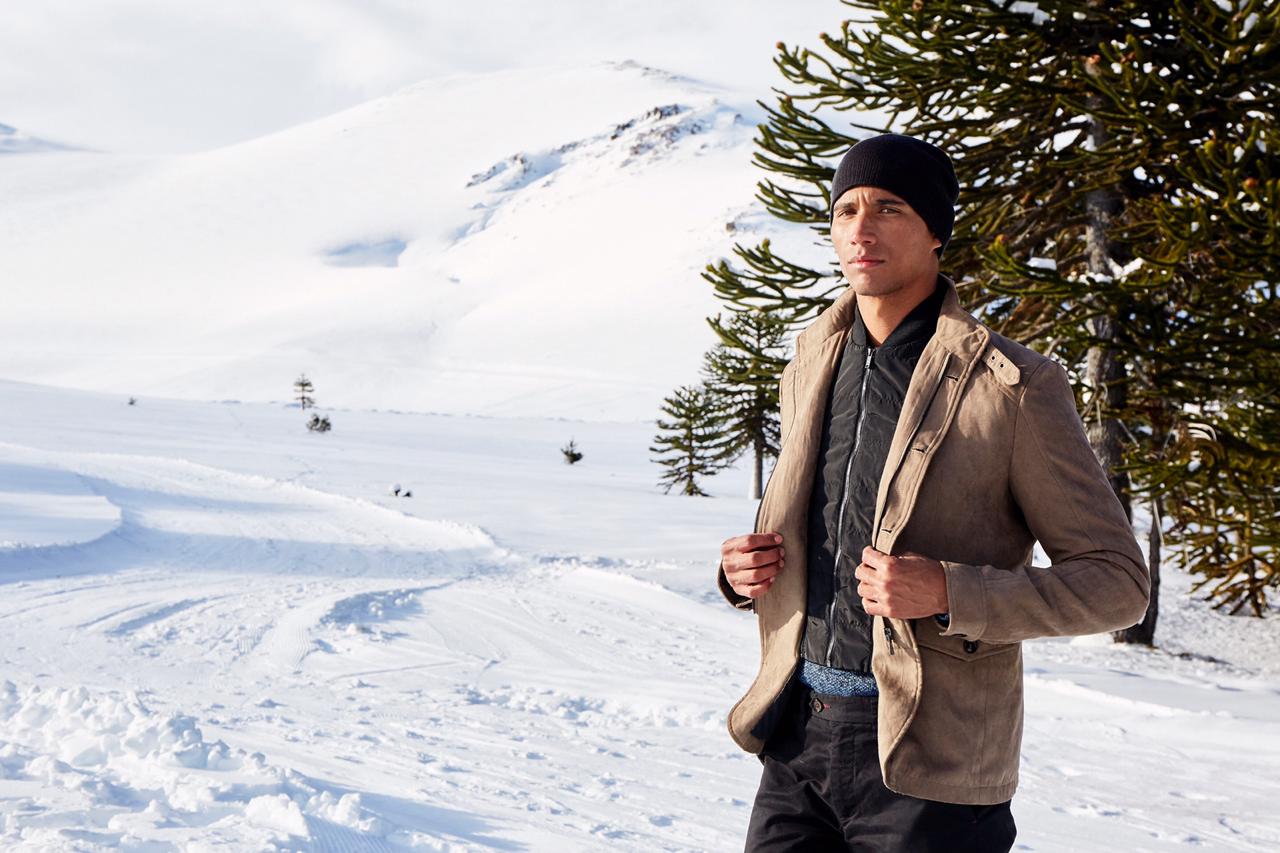Imagen de un hombre modelanod ropa de invierno en meio de los bosques nevados de Malalcahuello