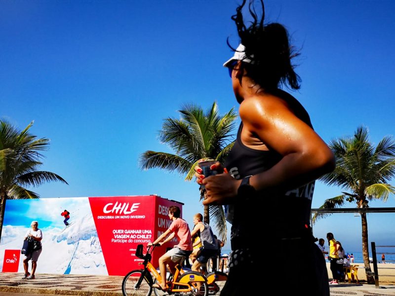 Imagen de una mujer corriendo por las playas de Brasil y de fondo se ve el logo y la promoción de Chile