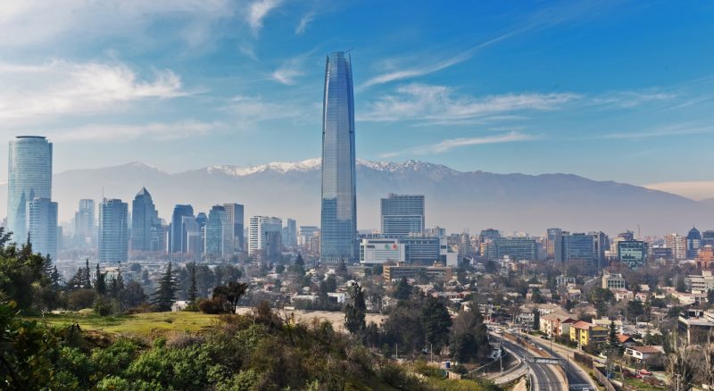 Imagen panorámica de Santiago donde destacan edificios en altura  con un cielo azul despejado