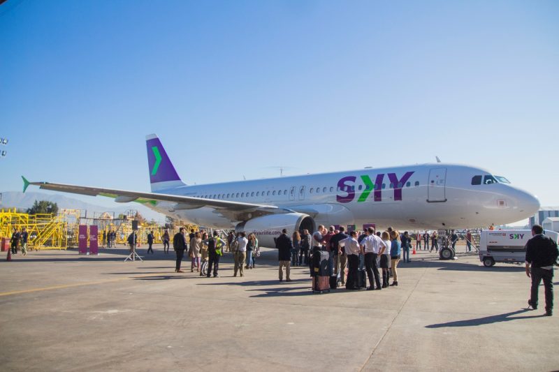 Imagen de un avión de Sky en el aeropuerto rodeado de gente