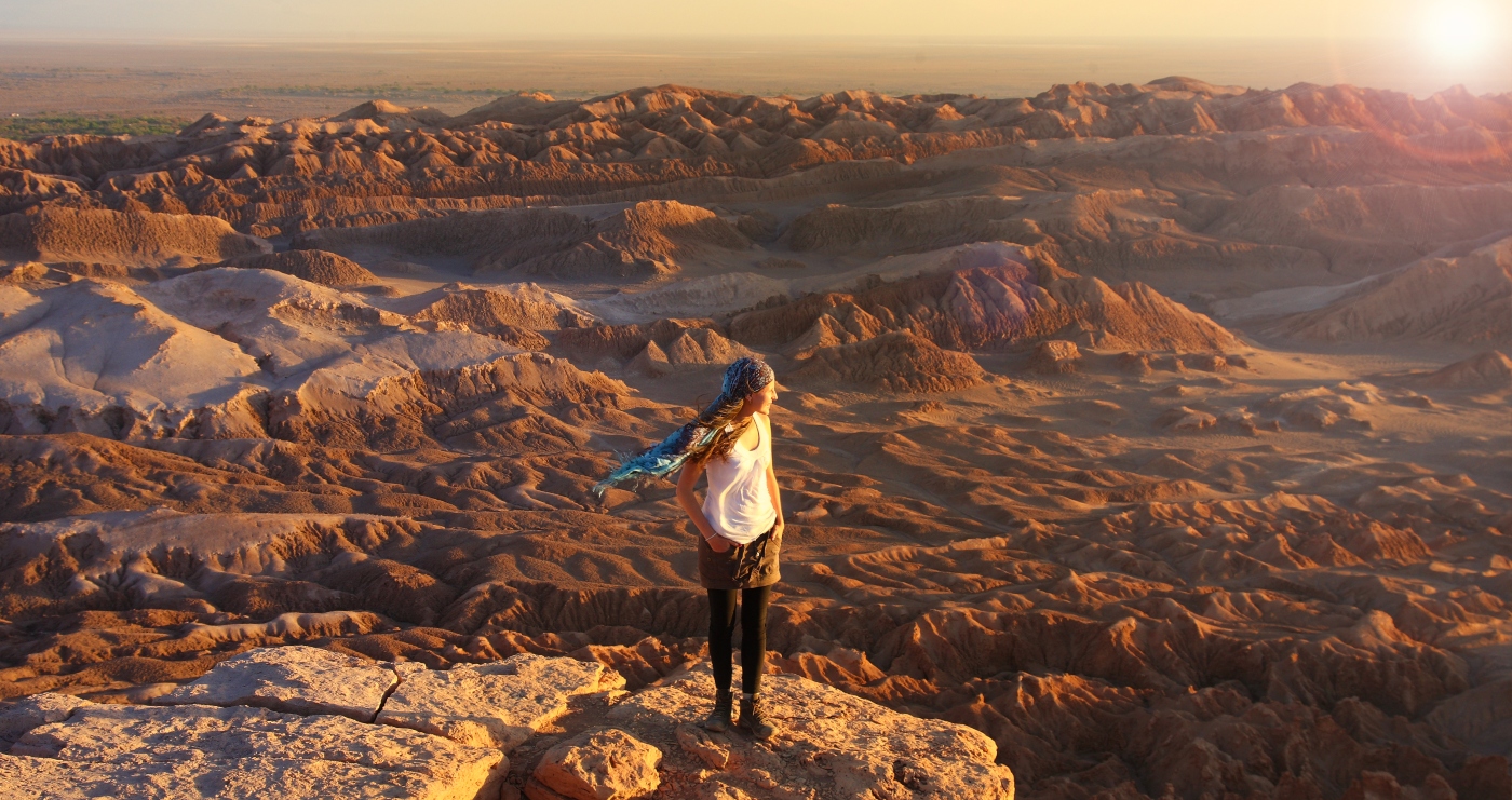 Imagen de una turista disfrutando la vista del Desierto de tacm, en medio del Valle de la Luna