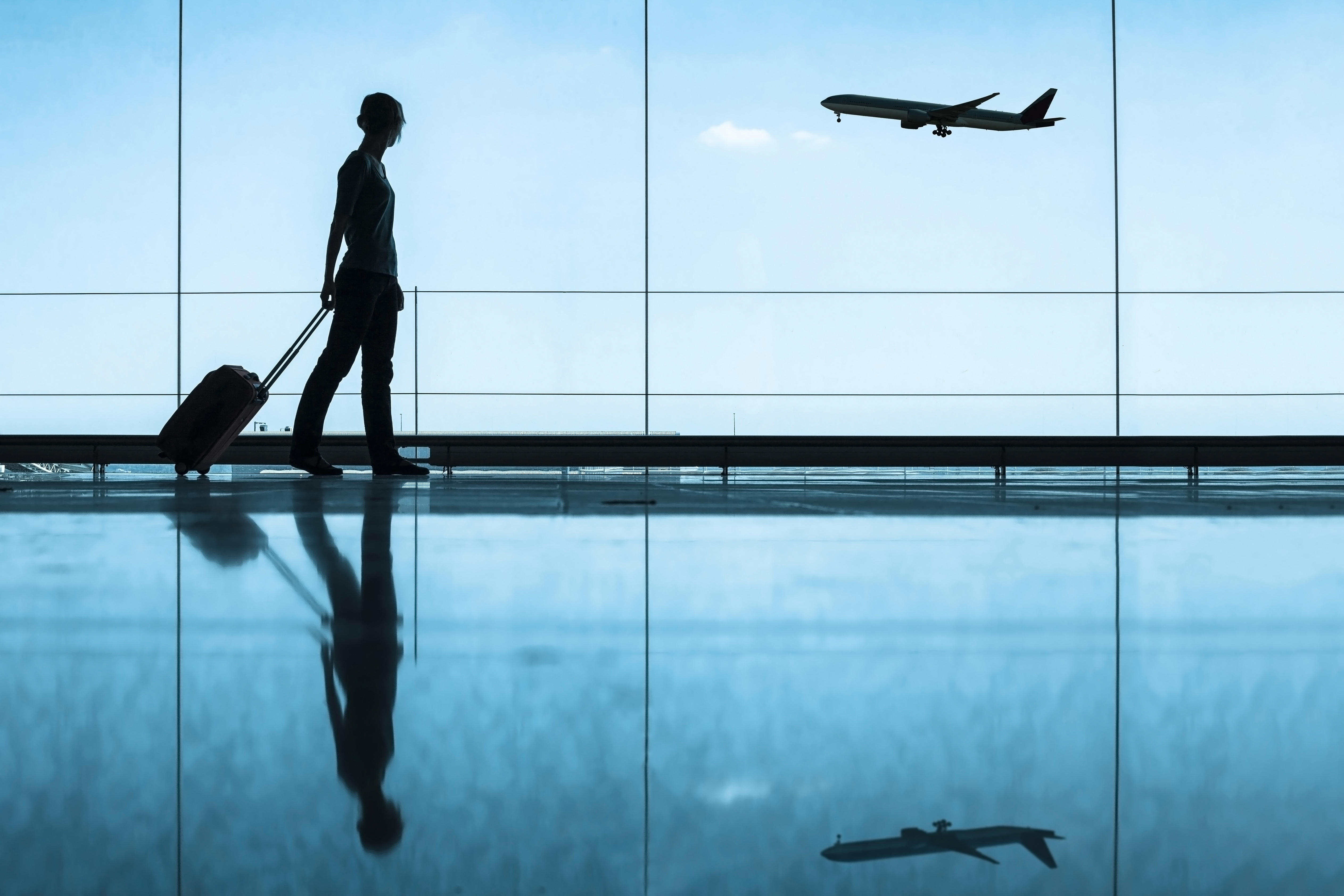 Mujer en sala espera aeropuerto con su maleta
