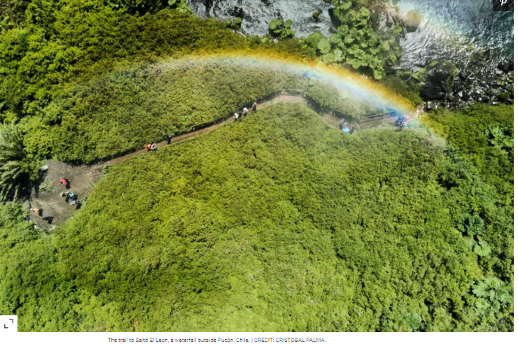 vista desde altura a paisaje natural y verde atravesado por un arcoíris