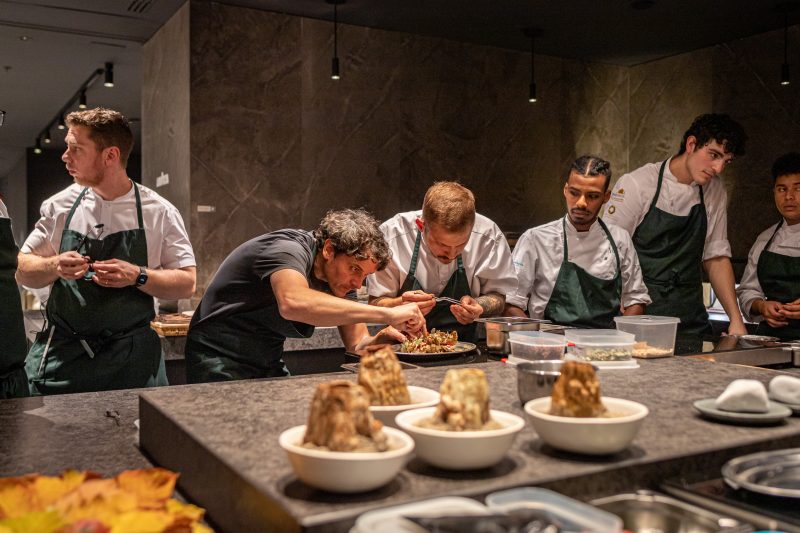 Rodolfo Guzman emplatando los platos junto a sus asistentes de cocina